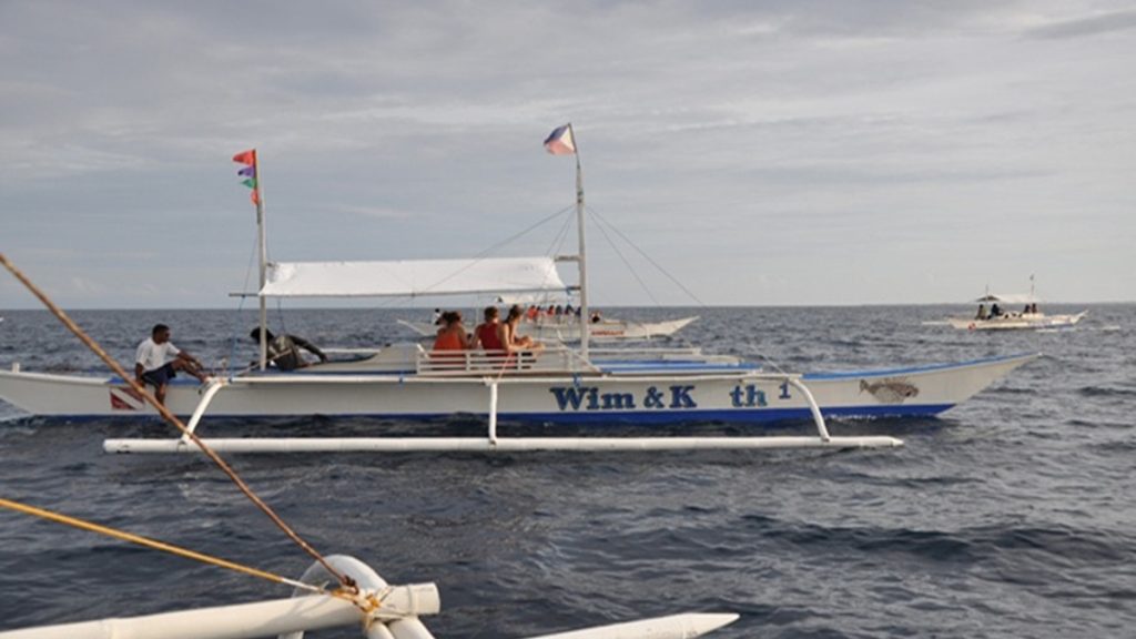 Bohol island hopping tour with boats visiting white sand islands and clear blue waters
