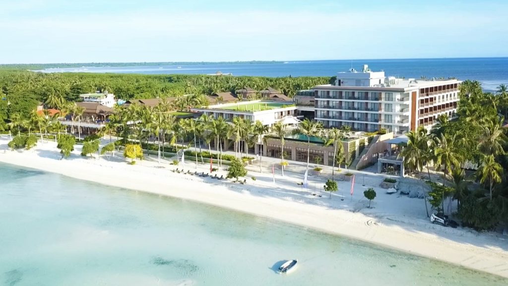 Aerial view of Modala Beach Resort surrounded by palm trees and turquoise sea
