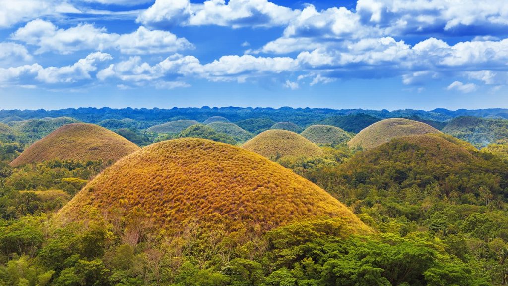 Tourists enjoying the Chocolate Hills and countryside views during a Bohol tour in the Philippines