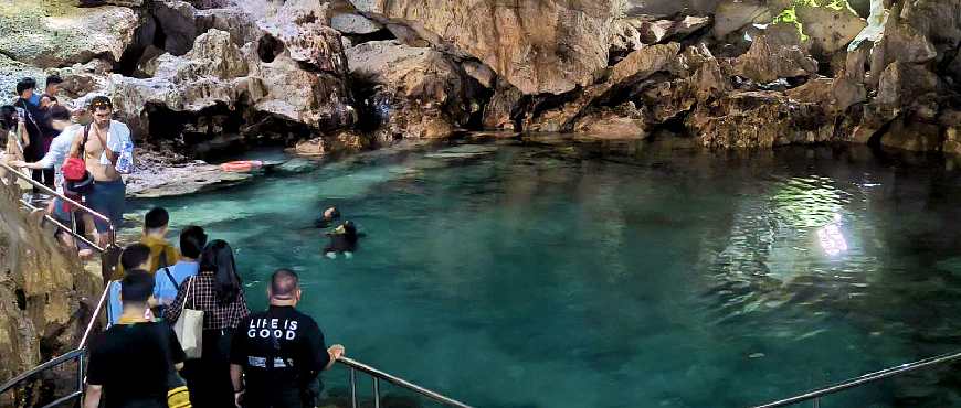 Hinagdanan Cave attraction in Dauis, Bohol with stone steps leading down to a natural cave lagoon