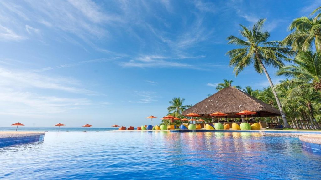 Oceanica Resort Panglao beachfront with white sand, palm trees, and clear blue sea