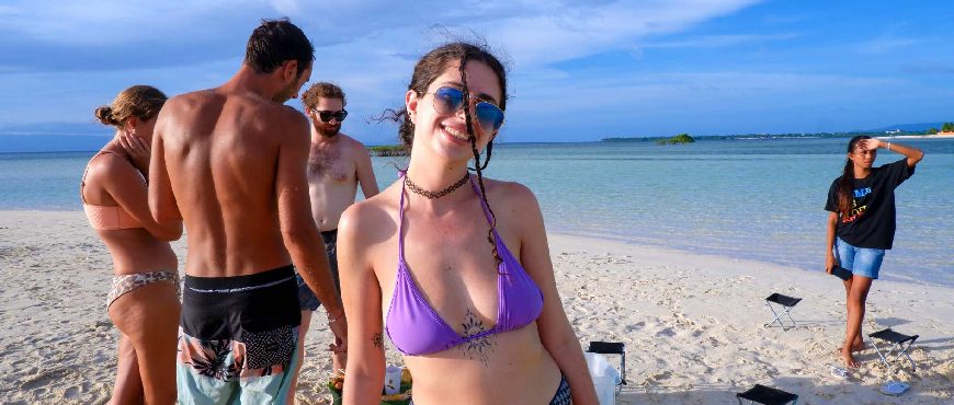 Visitors enjoying the white sandbar and clear shallow waters of Virgin Island in Bohol, Philippines, under a bright blue sky.