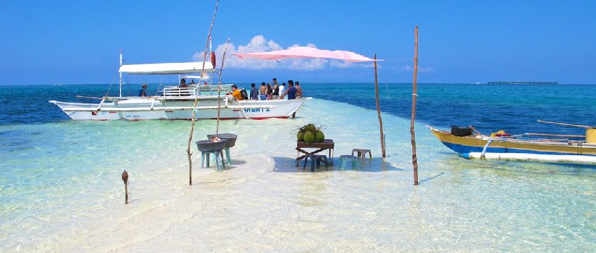 Virgin Island Bohol sandbar with crystal-clear turquoise water, anchored boats, and visitors enjoying the shallow shoreline.