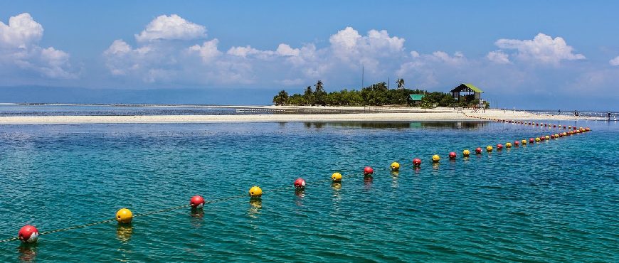 Virgin Island in Bohol with a white sandbar, clear turquoise water, and a small island under a blue sky.