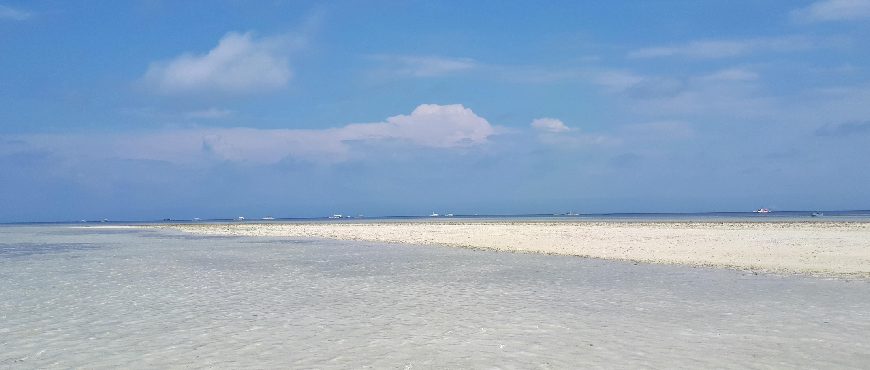 Virgin Island Bohol sandbar with clear shallow waters, white sand, and blue sky at low tide.